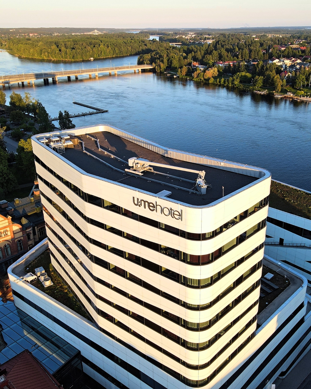 Ett ovanifrånperspektiv på byggnaden U&Me hotell i kvällssolens sken